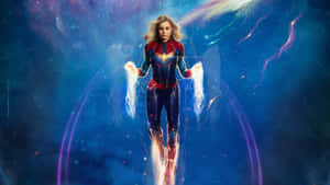 Captain Marvel 漂浮在太空中，帶有發光能量效果，身後是色彩繽紛的星雲。 — 驚奇隊長 壁紙