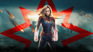 Captain Marvel 穿著戰衣，雙手發光，紅色能量光束在戰鬥場景中。 — 漫威復仇者聯盟 壁紙