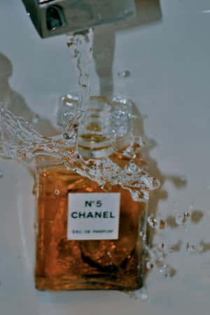 Chanel N5 香水瓶在浴缸中，周圍有水花四濺。 — 香奈兒 壁紙