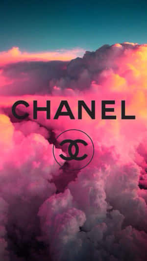 Chanel 標誌居中於粉紅色、橙色和藍綠色的彩色雲朵上。 — 香奈兒 壁紙
