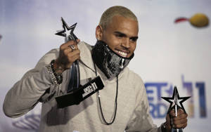 Chris Brown 微笑著手持兩個 BET Awards 獎盃。 — 克里斯·布朗 壁紙