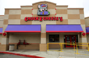 Chuck E Cheese's 餐廳，有卡通老鼠吉祥物和紫色遮陽篷。 — 查克芝士 壁紙