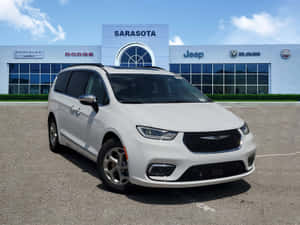 白色 Chrysler Pacifica 小型貨車在晴朗日子停放在經銷商處。 — 奧迪 GIF 壁紙