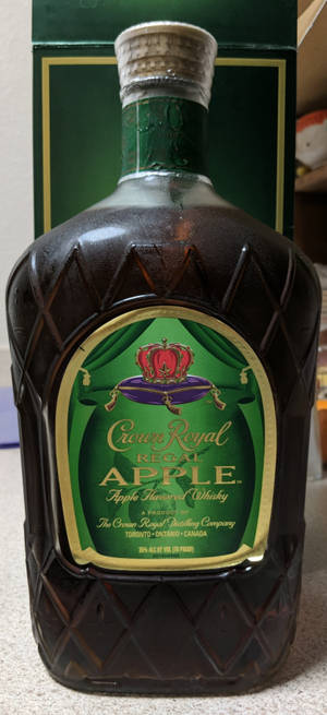 一瓶帶有綠色標籤和皇冠標誌的 Crown Royal Regal Apple 威士忌。 — Pixel 11 壁紙