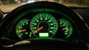 夜間帶有綠色照明儀表的汽車儀表板。