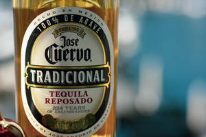 Jose Cuervo 龍舌蘭酒瓶特寫，金色液體和詳細標籤。 — 標誌 壁紙