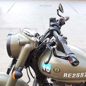 帶有賽車貼紙的橄欖綠色摩托車停放在人行道上 — 巴布風機車 壁紙