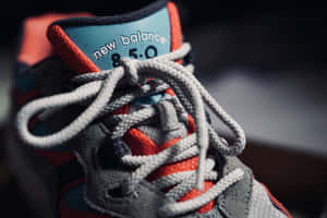 New Balance 850 運動鞋特寫，灰色鞋帶，紅藍色點綴。 — New Balance 壁紙