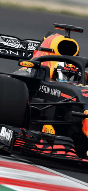 帶有Aston Martin品牌標誌的Red Bull Racing一級方程式賽車在賽道上。 — iPhone 13 Mini 壁紙