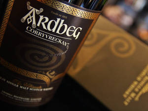 Ardbeg Corryvreckan 威士忌酒瓶特寫，帶有金色凱爾特圖案。 — 金色動態 壁紙