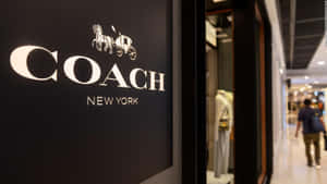 購物中心內的Coach New York店鋪標誌，帶有馬和馬車標誌。 — 教練 壁紙