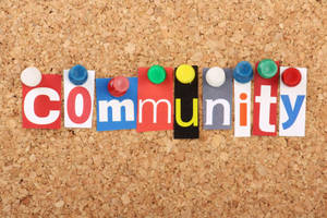 彩色剪字拼出「community」一詞，釘在軟木板上。