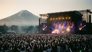 日出時，以富士山為背景的戶外演唱會人群。