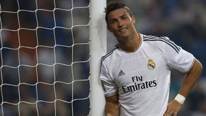 Cristiano Ronaldo 身穿皇家馬德里球衣靠在足球門柱上微笑。
