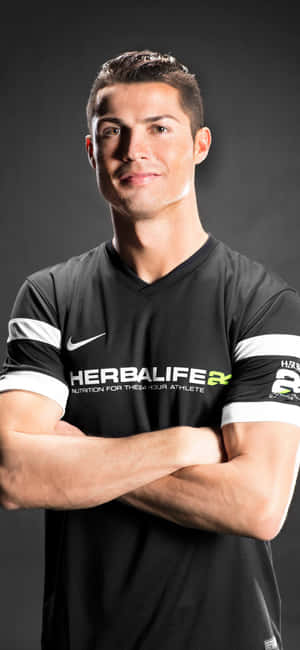Cristiano Ronaldo 身穿黑色Herbalife球衣交叉雙臂微笑 — Galaxy A16 壁紙