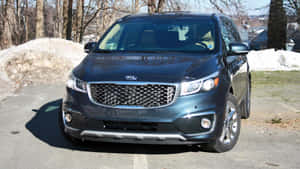 深灰色Kia Sorento SUV停放在積雪車道上，有正在融化的雪堆和光禿樹木。 — 起亞 壁紙