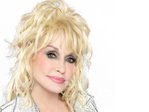 Dolly Parton 微笑，金髮和銀色外套。
