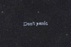 在星空夜空背景下顯示「Don't panic」的文字。 — 恐慌 壁紙