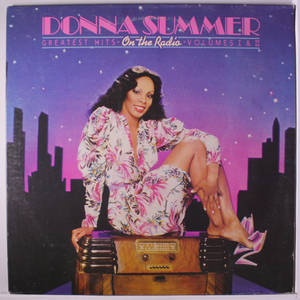 Donna Summer 穿著花卉圖案連衣裙，坐在復古收音機上，背景是夜晚城市天際線。 — 復古 壁紙