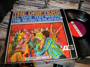 The Drifters 跳舞插圖的黑膠唱片封套，周圍環繞著一堆堆唱片。 — 音樂 壁紙