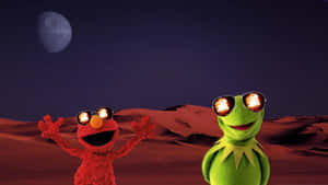 Elmo 和青蛙 Kermit 戴著太陽眼鏡，在紅色沙漠上，天空中有死星。 — 科米蛙 壁紙