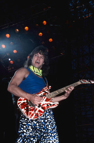 Eddie Van Halen 在舞台上用明亮燈光彈奏吉他。 — 岩石 壁紙