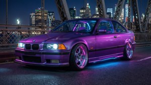 夜間城市橋上的紫色BMW E36雙門轎跑車，帶有發光的霓虹燈。