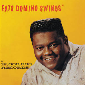 Fats Domino 在《Swings》專輯封面上微笑，背景為黃色並帶有文字。 — 骨牌 壁紙