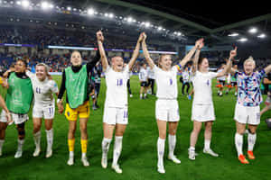女子足球隊在夜間燈光球場上慶祝勝利。 — 足球員 壁紙