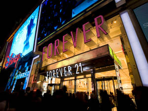 夜晚的 Forever 21 商店，帶有霓虹燈和外面的人群。 — 永遠21 壁紙