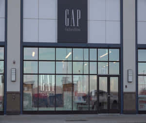 GAP Factory Store 正面，帶有關閉標誌和反射周圍環境的玻璃窗。 — 間隙 壁紙
