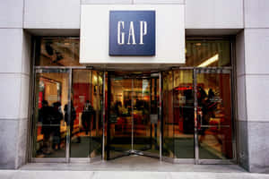 Gap店舖正面，設有玻璃旋轉門，行人進出。 — 美學天空 壁紙