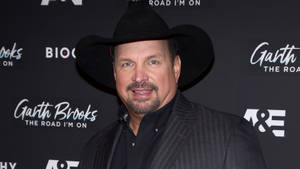 Garth Brooks 在宣傳活動中戴著黑色牛仔帽和西裝。 — 音樂 壁紙