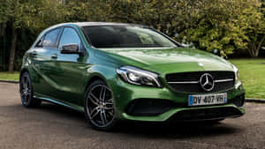 綠色賓士A-Class停在鋪砌的道路上，周圍有樹木和草地。 — Mercedes-Benz 壁紙
