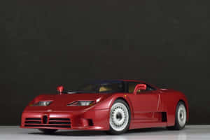 紅色Bugatti EB110模型車放在白色表面上，背景為深灰色。 — Surface Pro 壁紙