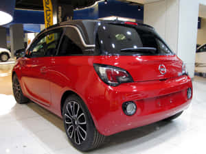 紅色Opel Adam汽車在展廳中展示，地板閃亮並有天花板燈光。 — 歐寶 壁紙