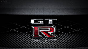 碳纖維表面上的 GTR 標誌，帶有金屬紅色和銀色飾面。
