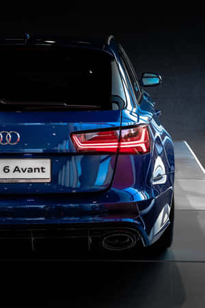 藍色Audi A6 Avant在黑暗工作室環境中尾部視圖，尾燈亮起。 — Oppo Pad Mini 壁紙