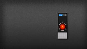 HAL 9000 電腦眼睛在深色紋理牆壁上發出紅光。 — 機器人 壁紙