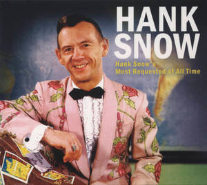 Hank Snow 身穿粉紅色花卉西裝，拿著一個貼有貼紙的旅行手提箱。 — 音樂 壁紙