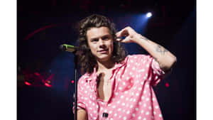 Harry Styles 穿著粉紅色圓點襯衫在舞台上唱歌。 — 哈利波特 筆電 壁紙