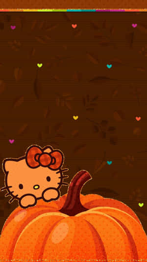 Hello Kitty 從南瓜後面探出頭來，秋葉中漂浮著心形。 — Hello Kitty 萬聖節 壁紙