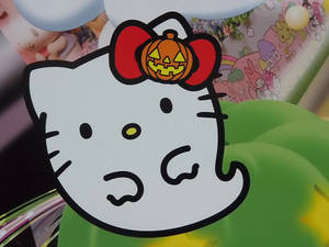 Hello Kitty 在節日卡通場景中戴著南瓜蝴蝶結。 — Hello Kitty 萬聖節 壁紙