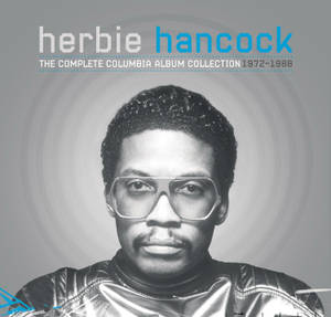 Herbie Hancock 的黑白肖像，戴著大眼鏡和閃亮外套。 — 音樂 壁紙