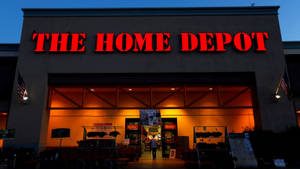 Home Depot 商店正面在黃昏時亮起，帶有紅色標誌和美國國旗。 — 好市多 壁紙