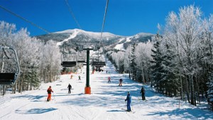 滑雪者在積雪的山坡上，有纜車和積雪的樹木。