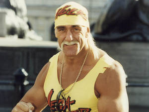 Hulk Hogan 身穿黃色摔角服裝，露出自信的笑容。 — 霍克·霍肯 壁紙