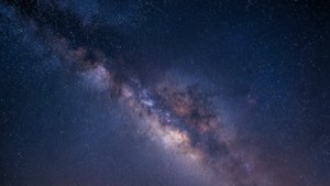 在黑暗夜空中閃耀著宇宙塵埃和星星的銀河系。