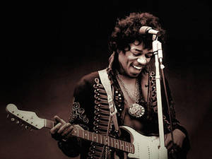 Jimi Hendrix 在舞台上彈奏電吉他，表情愉快。 — 好萊塢 壁紙