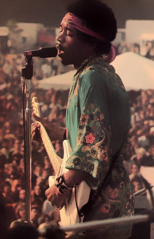 Jimi Hendrix 在音樂會上以吉他和麥克風現場表演。 — Galaxy Tab S10+ 壁紙